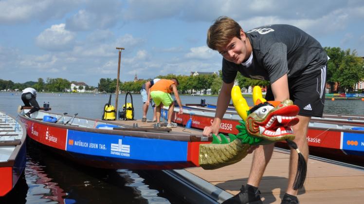 Vorbereitung vor dem Start: Justus Unger bringt an einem der Boote den namensgebenden Drachenkopf an.  