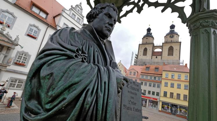 Denkmal des Reformators Martin Luther  mit der von ihm ins Deutsche übersetzten Bibel in der Hand. Sein Thesenanschlag in Wittenberg wird auf das Jahr 1517 datiert.