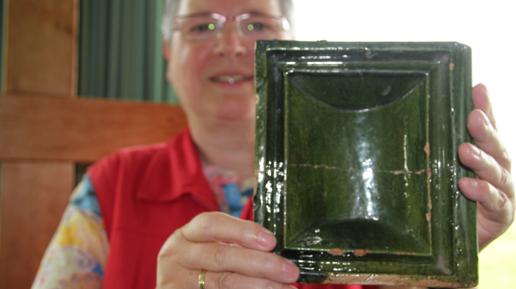 Sigrid Carow mit einer Ofenkachel, die Robert Brauer vor der Hallig Südfall auf dem Meeresboden gefunden hat. Carow hat zusammen mit Hellmut und Rita Bahnsen sowie Peter Herschlein ein Buch über die „Schätze aus dem Watt“ veröffentlicht. 