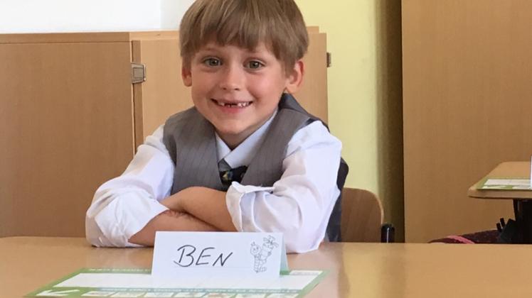 Zum ersten Mal sitzt Ben Harder bei seiner Einschulung auf seinem Platz im Klassenzimmer.  