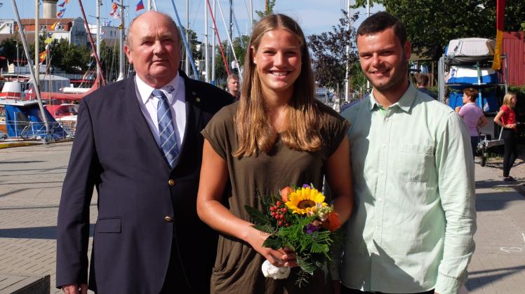 Blumen für die frisch gebackene Weltmeisterin: Präsident Bodo Bartmann (links) und Jugendwart Jakob Schrank freuten sich mit Hannah Anderssohn über den Titel in der olympischen Laser-Radial-Klasse.  