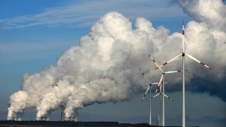 Lausitzer Energiemix: Windräder drehen sich vor den Kühltürmen des Braunkohlekraftwerks Jänschwalde (Spree-Neiße).  