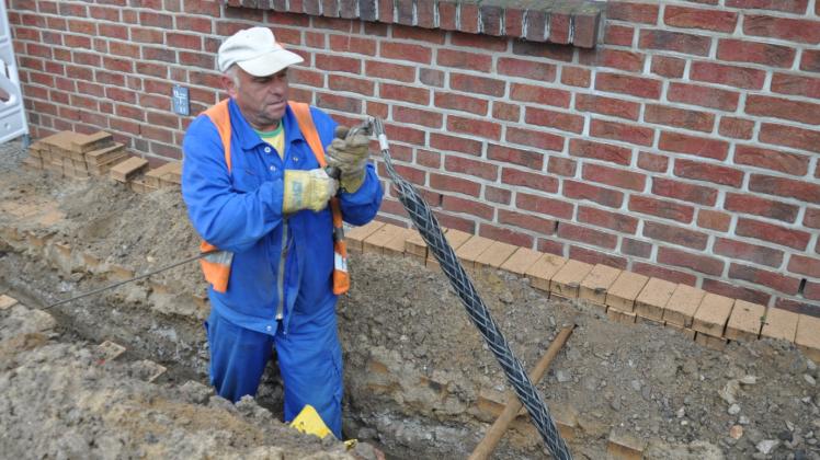 Beim Ausheben des Grabens für das neue Kabel musste Hans Merseburger – hier gestern beim Anklemmen des Zugseils an den „Ziehstrumpf“ – mit seinem Bagger sehr auf gleich mehrere im Boden verlegte Leitungen aufpassen, wie man an obigen Warnbändern sieht Fotos: Ilja Baatz . Beim Ausheben des Grabens für das neue Kabel musste Hans Merseburger – hier gestern beim Anklemmen des Zugseils an den „Ziehstrumpf“ – mit seinem Bagger sehr auf gleich mehrere im Boden verlegte Leitungen aufpassen, wie man an obigen Warnbändern sieht Fotos: Ilja Baatz .