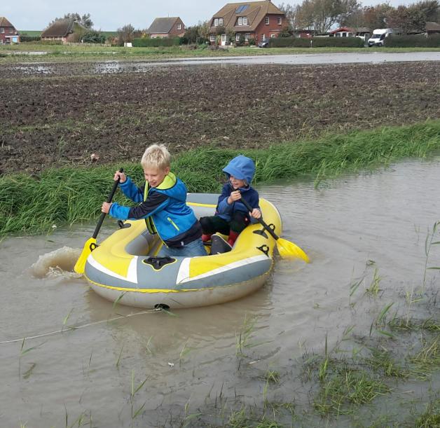 Lorenz Jansen (8) und Sören Meesenburg (7) sind mit dem Schlauchboot auf dem Feld unterwegs.