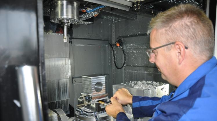 Firmenchef Peter Lemke  bestückt eine vollautomatische Fräsmaschine.  