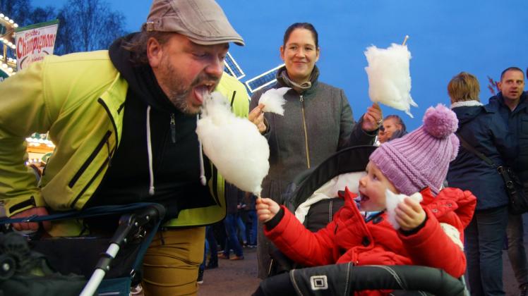 Klein Mathilda füttert ihren Papa Martin mit Zuckerwatte. Klein Mathilda füttert ihren Papa Martin mit Zuckerwatte.
