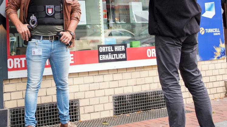 Durchsuchung: Polizisten haben sich vor einem Handyladen in Hamburg-Wilhelmsburg postiert. 