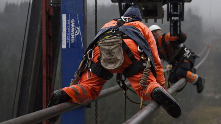 Arbeiter balancieren auf den Tragseilen der neuen Zugspitz-Seilbahn. Arbeiter balancieren auf den Tragseilen der neuen Zugspitz-Seilbahn.
