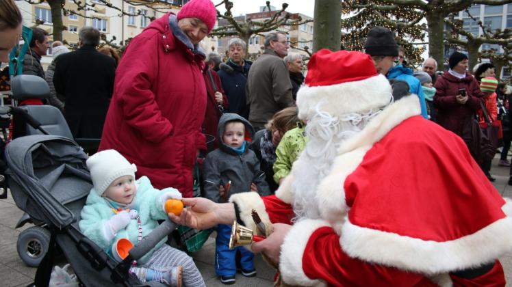 Der Weihnachtsmann waltet seines Amtes und beschenkt die jüngsten Besucher des Weihnachtsmarktes.  