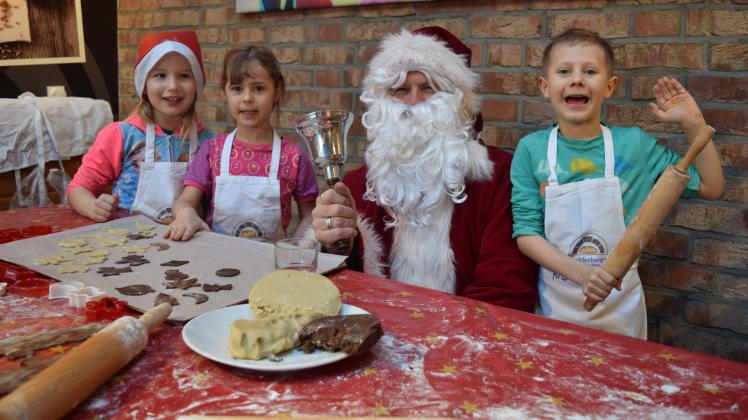 Weihnachtsbäckerei: Mit dem Weihnachtsmann haben Valeriya (5), Emmi (5) und Timm (7, v. l.) Plätzchen gebacken. 