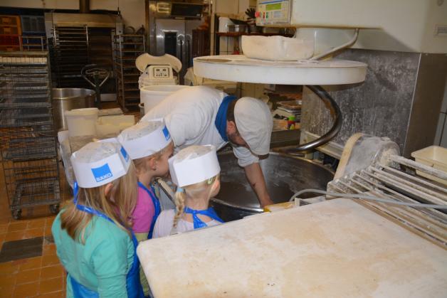 Bäckermeister Thomas Mahnke zeigt den Kleinen, wo der Teig geknetet wird.