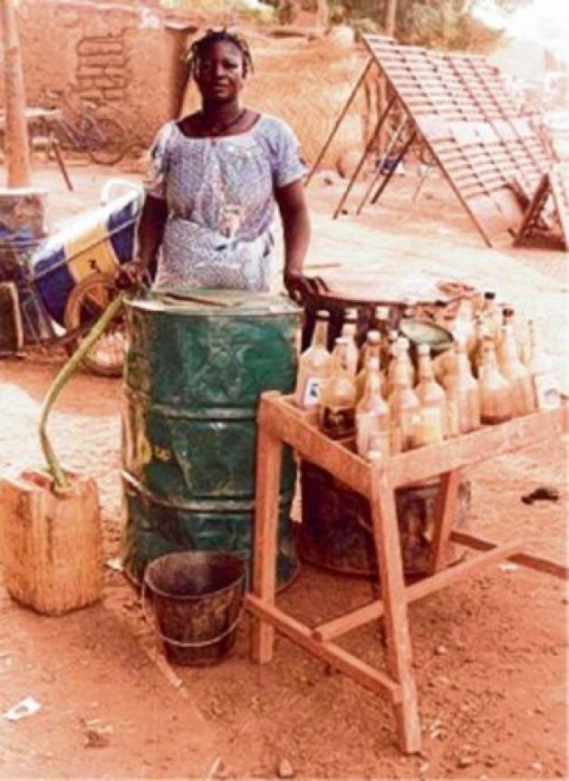 Eine Tankstelle für Sien: In den Flaschen, die diese Frau verkauft, ist Benzin für Mofas.