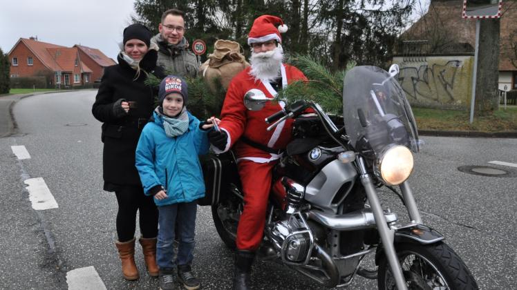 Überraschung am Klein Rogahner Dorfteich: Der Weihnachtsmann kommt mit dem Motorrad angefahren beschenkt den neunjährigen Luis. 