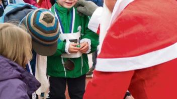 Torge Petersen-Feddersen bekommt nach dem Ruprechtlauf  etwas Süßes vom Nikolaus.  Foto: Dewanger"