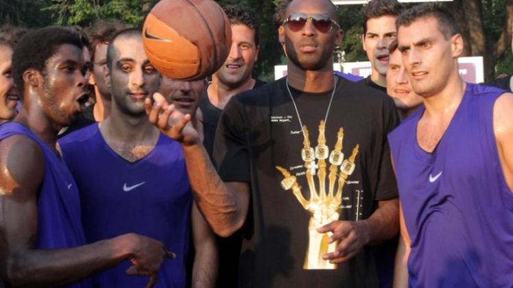 Kobe Bryant (M) bei seinem Stopp in Mailand.