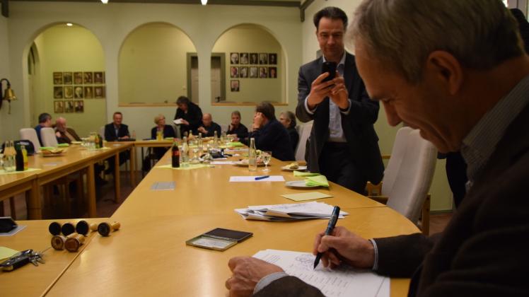 Bei Brötchen und Getränken unterschreibt Kappelns Bürgermeister Heiko Traulsen das Papier, das die Gründung des Zweckverbandes „Interkommunales Gewerbegebiet Nordschwansen“ besiegelt. Thorsten Liliental (Wirtschaftsförderung Rendsburg-Eckernförde) hält den Moment im Bild fest.