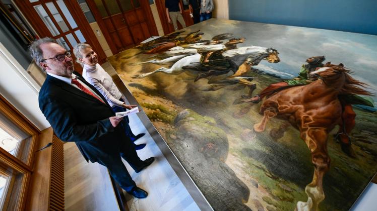 Landtagsdirektor Armin Tebben und Petra Kruse vom Sammlungsmanagement bestaunen das Gemälde „Niklots Tod“.  Fotos: Volker Bohlmann 