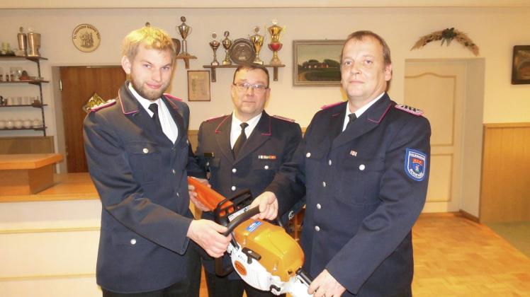 Jens Beckmann, Jürgen Köller und Axel Nissen  (v. li.) präsentieren stolz die neue Motorsäge.
