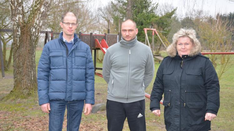 Berend Baarslag, Marcel Hintze und Bürgermeisterin Cornelia Wiedow am Gemeindetreff in Zierzow. Im Hintergrund der Spielplatz, der bald neue Spielgeräte bekommen soll. 