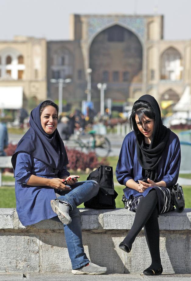 Junge Frauen – mit Handy – auf dem Imam Platz vor dem Eingang zum Basar in Isfahan.