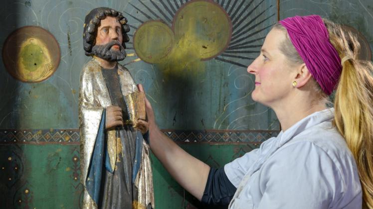 Restauratorin Dorothee Schmidt-Breitung hält eine Heiligenfigur in der Hand. 