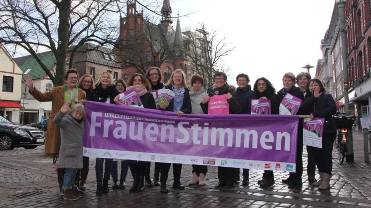 Mit einem knalligen Banner  machen Vertreterinnen vieler Institutionen auf den Internationalen Frauentag aufmerksam.
