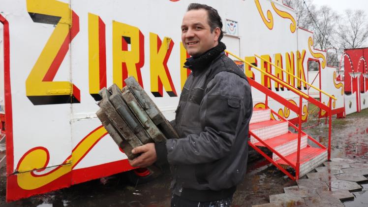 Extra ausgeliehen: Patrick Sperlich befestigt mit Gummiplatten den Weg zum Zirkuseingang auf dem Festplatz an der Bleiche in Güstrow.  