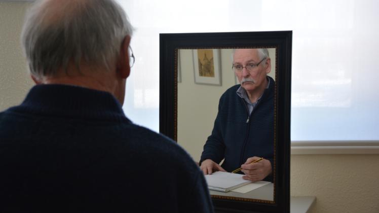 Versucht sich an einem Selbstporträt: Museumsleiter Heiko Brunner betrachtet sich im Spiegel. 