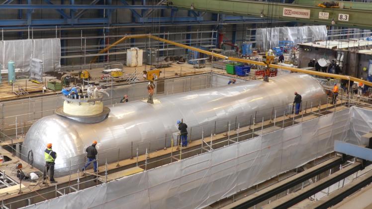 In das Maschinenraum-Modul setzen Arbeiter der Neptun-Werft den 28 Meter langen und 200 Tonnen schweren Tank für Flüssigerdgas ein. 