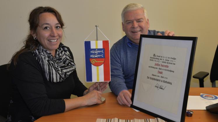 Natalie Niehus vom Zarrentiner Gewerbeverein mit dem aktuellen Stadtwappen und Bürgermeister Klaus Draeger mit der amtlichen Urkunde zur Verleihung des Stadtrechtes. 