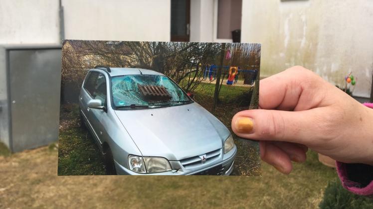 Eine Nachbarin zeigt das Foto eines zerstörten Autos. ⇥ Mathias Hausding  
