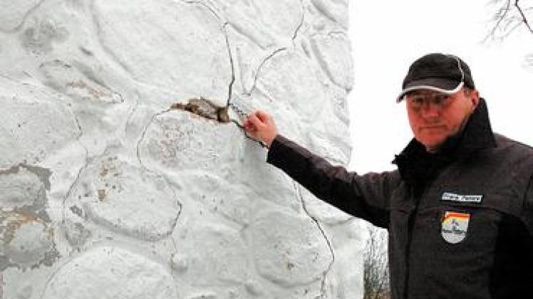 "Das ist nicht harmlos": Maler- und Lackierermeister Frank Peters misst die Größe der Risse am Mauerwerk der Kirche. Foto: Laabs