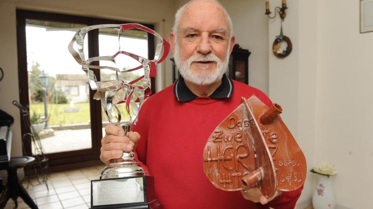 Einen Sportpokal und ein stilisiertes Herz aus Ton hält Ingo Mruk in den Händen. Der 78-Jährige lebt dank eines fremden Herzens und hält sich mit Sport fit.