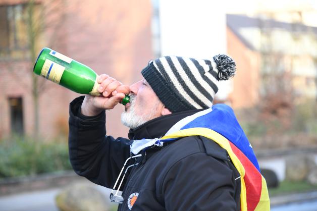 Eduard Alonso aus Girona in Katalonien, ein Unterstützer Puigdemonts, trinkt vor der Justizvollzugsanstalt aus einer Flasche Sekt.