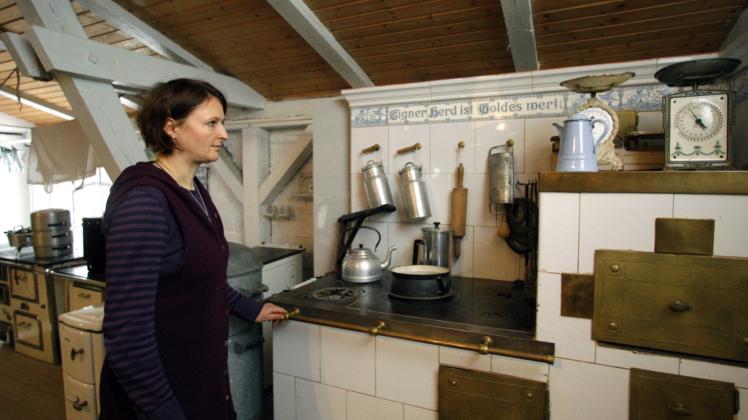 Eine Frau mustert in Velten einen Küchenherd. 