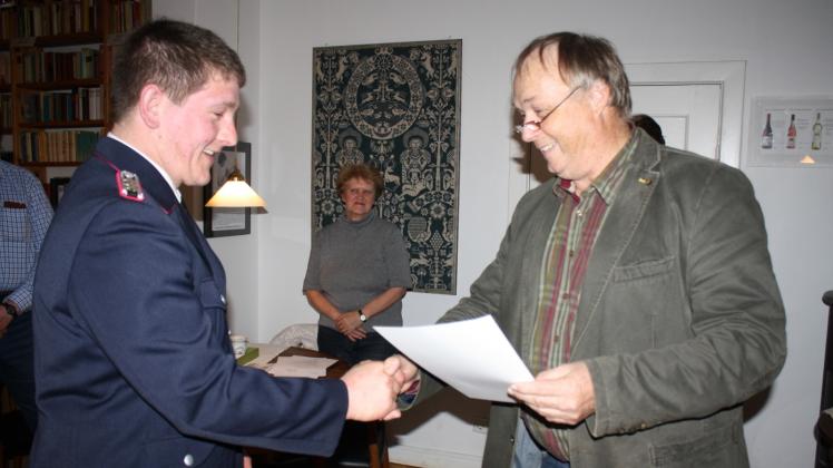 Bürgermeister Jörg Nissen überreicht die Ernennungsurkunde an den neuen stellvertretenden Wehrführer Mathias Steensen. 