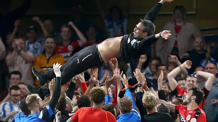 Die Spieler von Huddersfield Town feiern den Klassenerhalt an der Stamford Bridge und lassen ihren Trainer David Wagner hochleben.