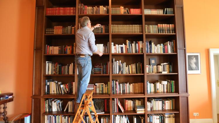 Manfred Achtenhagen, Betreiber von Gutshaus Ludorf, steht in der Bibliothek vor einem Teil der alten Gutsbibliothek, die nach mehr als 70 Jahren ins Gutshaus zurückgekehrt ist.