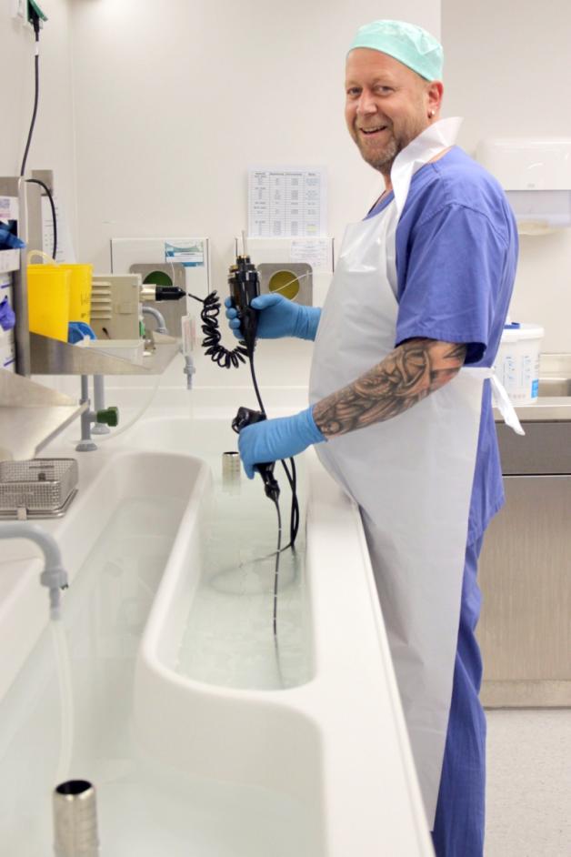 Ordentlich durchspülen: Sterilisationsassistent Knut Starker überprüft ein Endoskop auf undichte Stellen, bevor es in den Waschautomaten wandert.