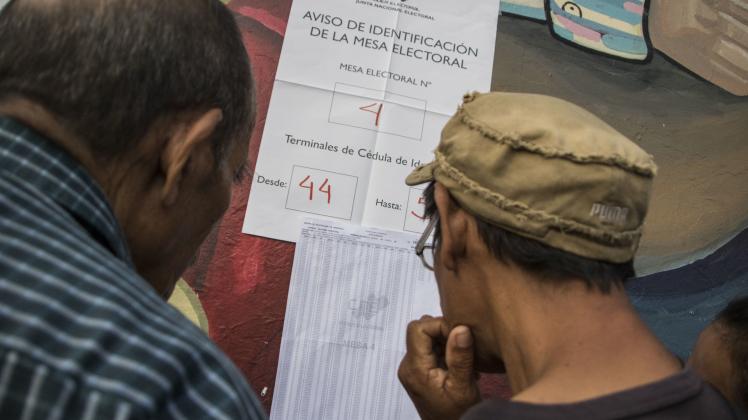 Bürger überprüfen auf Listen, wo sie ihre Stimme zur Präsidentenwahl abgeben können. Ein Sieg des sozialistischen Amtsinhabers Maduro gilt als so gut wie sicher.