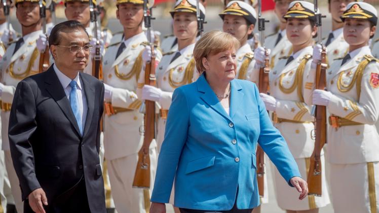 Angela Merkel wird vom chinesischen Ministerpräsidenten Li Keqiang (l) auf dem Ostplatz vor der Großen Halle des Volkes mit militärischen Ehren begrüsst.