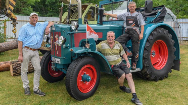 Holger Ackermann  (l.) , Ralf Tamzow und Ralf Wittke vom Verein Schlepperfreunde Philadelphia stehen an einem alten Traktor der Marke Hanomag, Typ Robust 800, Baujahr 1965. 