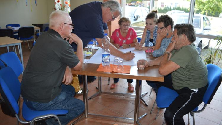 Was in eine Reportage aus der Gemeinde gehört, wurde gemeinsam zu Papier gebracht. An einem Tisch betätigt sich Prof. Dr.-Ing. Henning Bombeck (2.v.l.) als Schreiber. 
