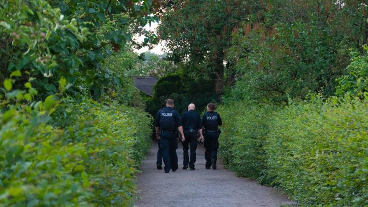 Polizeibeamte durchsuchen den Kleingartenverein nach Spuren.