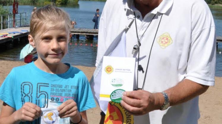 Starke Leistung: Thorben Schumann schaffte die Prüfungen für den Juniorretter. Schwimmlehrer Rolf Stiehler übergibt dem Neunjährigen die Urkunde. 