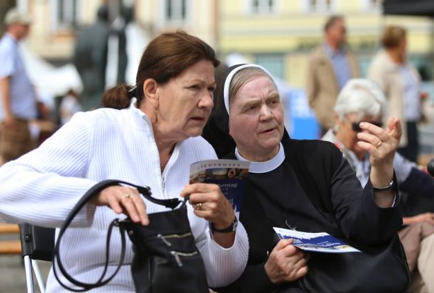Zwei Besucherinnen des Stadtkirchentages unterhalten sich während der Eröffnungveranstaltung auf dem Neuen Markt. 