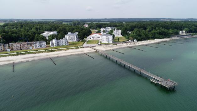 Das Ostseebad Heiligendamm mit der Seebrücke, dem Grand Hotel (M) und der "Perlenkette" (l) der historischen Häuser