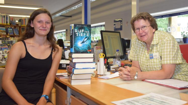 Ferien-Lese-Club-Teilnehmerin Stine Höhling (l.) hat sich mit Lesestoff für rund zwei Wochen eingedeckt, sehr zur Freude von Bibliothekarin Marie-Therese Fritzen-Einfeldt.