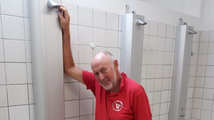 Sichtlich zufrieden: Ernst Hinrichsen in der neuen Dusche des Niebüller Hallenbads.