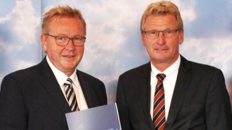 Bürgermeister Hans-Jürgen Lütje (l.) nimmt den Förderbescheid von Tourismusminister Bernd Buchholz entgegen.